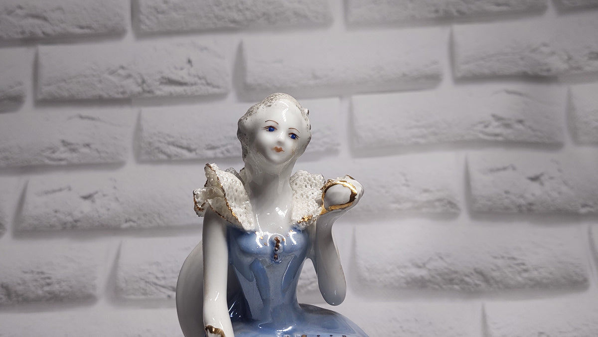 Porcelain vintage romanian figurine girl with flower.