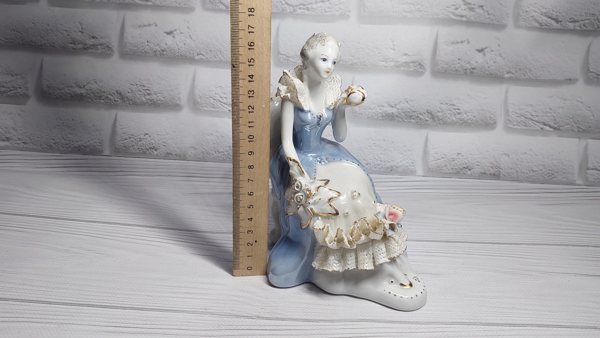 Porcelain vintage romanian figurine girl with flower.