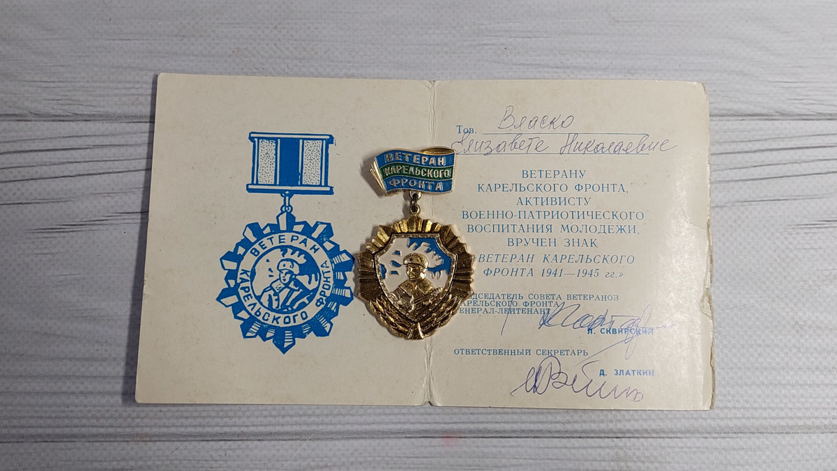 Old badge of the veteran of the Karelian front, with a document.