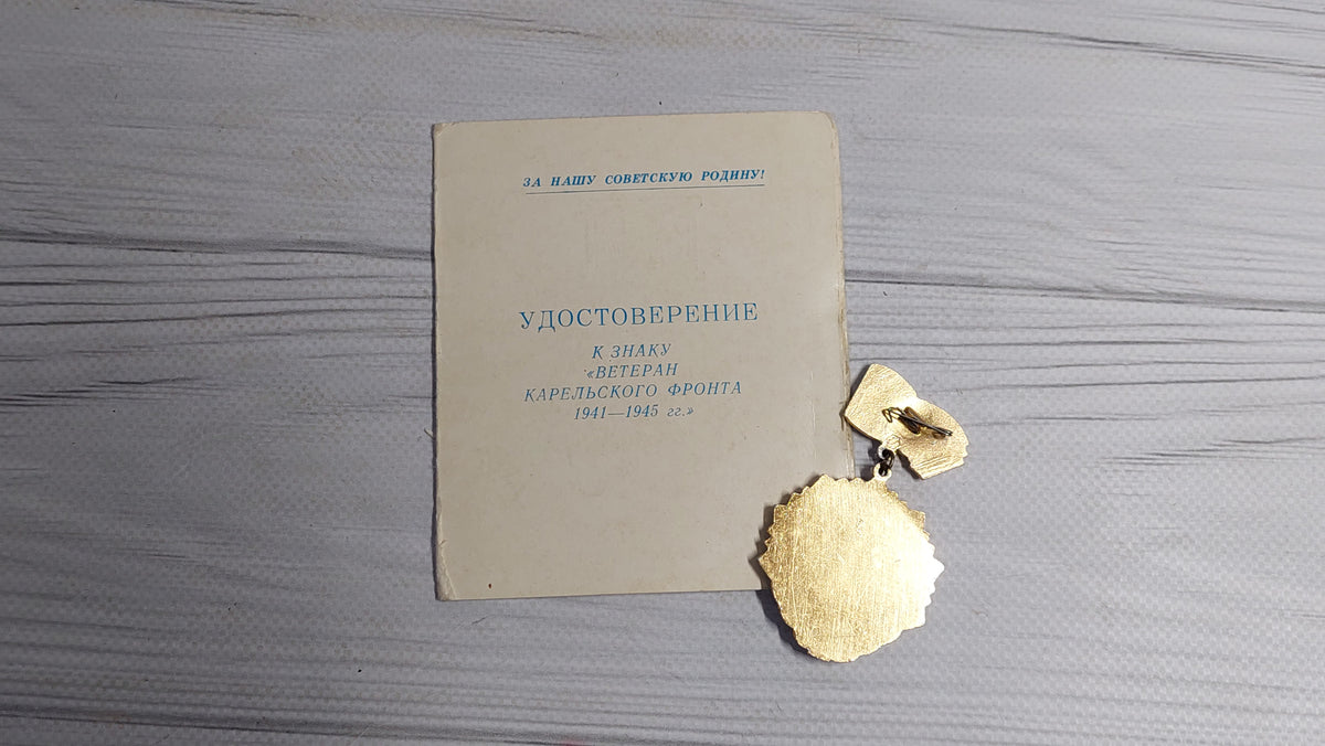 Old badge of the veteran of the Karelian front, with a document.