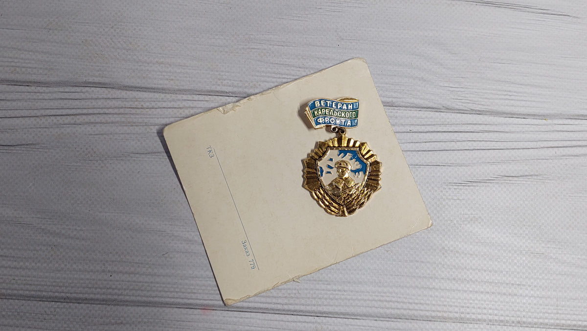 Old badge of the veteran of the Karelian front, with a document.