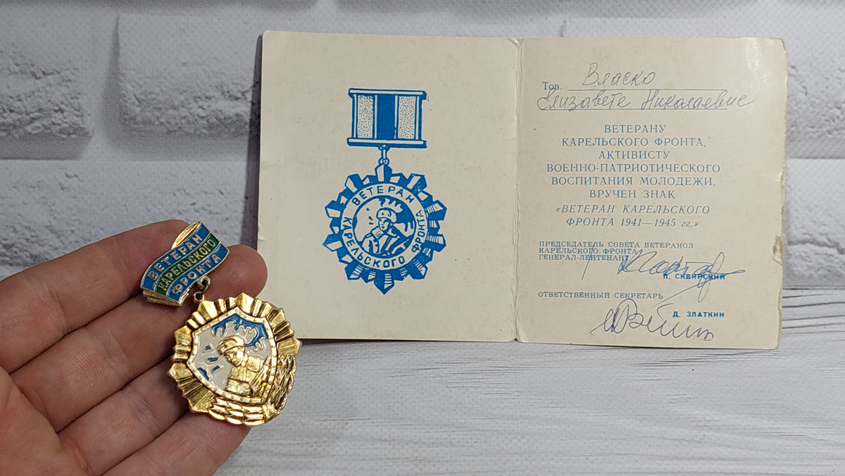 Old badge of the veteran of the Karelian front, with a document.