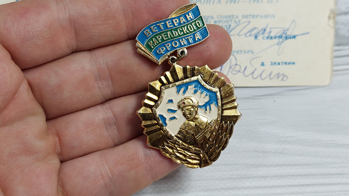 Old badge of the veteran of the Karelian front, with a document.