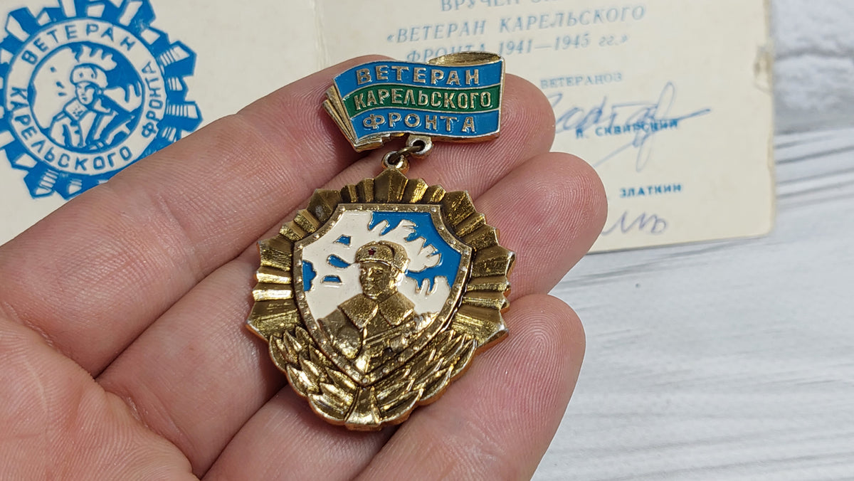 Old badge of the veteran of the Karelian front, with a document.